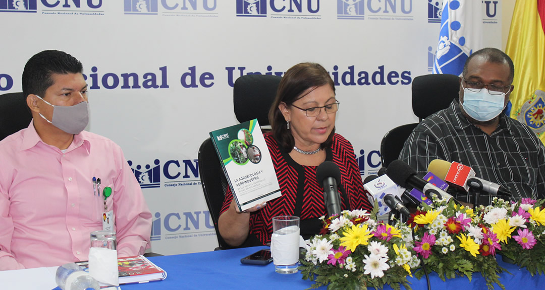 La presidenta del CNU, junto al Vicepresidente y Secretario General, mostrando el libro Agroecología y Agroindustria, bases del desarrollo rural en Nicaragua.