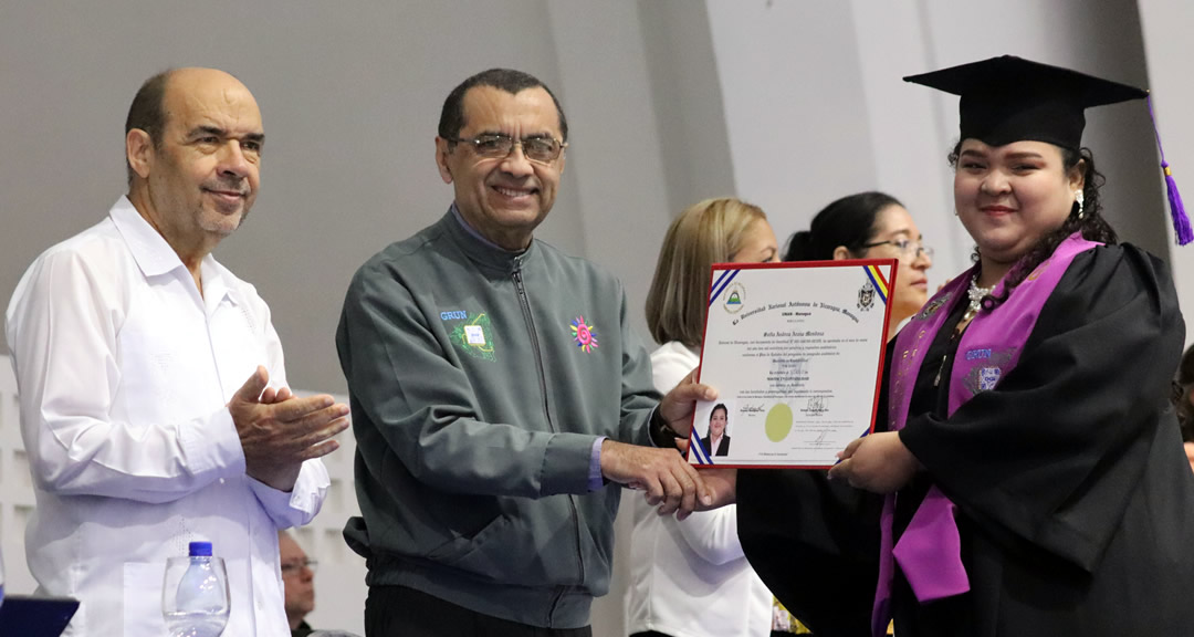 Graduada recibe título de manos del director general de la DGI.