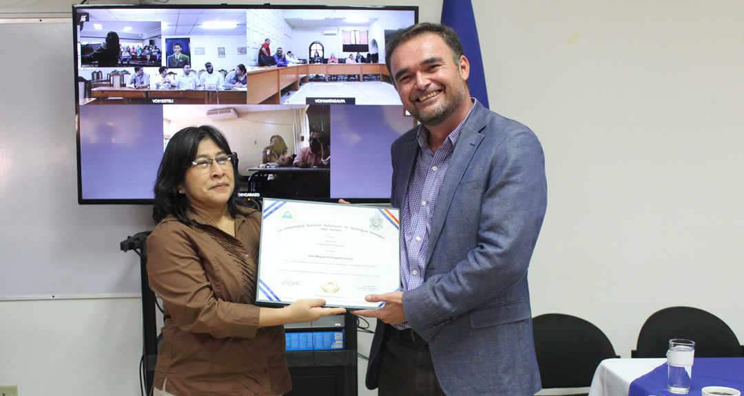 La Vicerrectora Administrativa y de Gestión, MSc. Sonia Orozco, entrega diploma de Visitante Distinguido al MSc. José Miguel Rodríguez García.