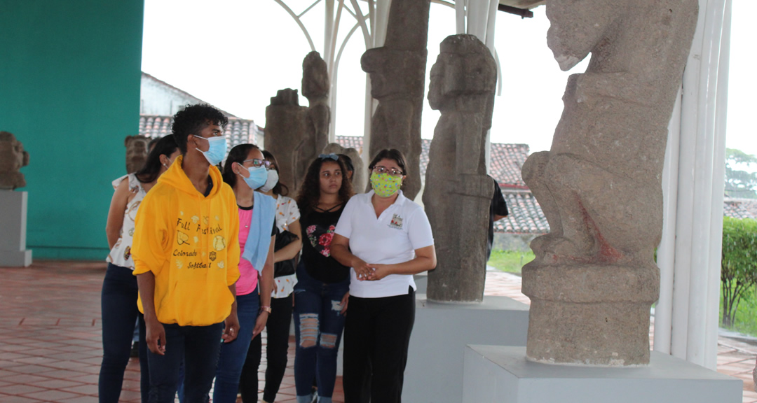 Guía del museo les explica a los estudiantes la antigüedad y significado de los petroglifos