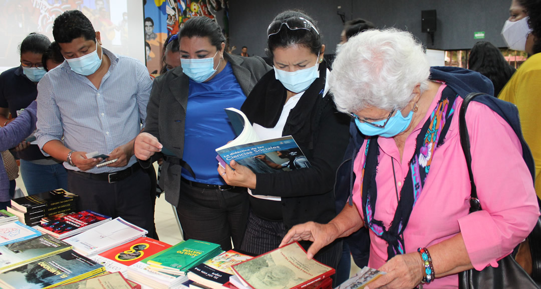 Asistentes del Encuentro en los estands que contienen publicaciones académicas y científicas.