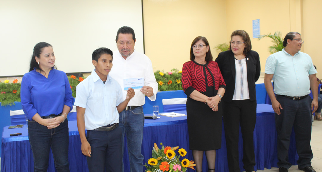 Mameli Sevilla Méndez recibiendo de parte del Asesor Presidencial para Temas de Educación, Salvador Vanegas, el certificado que lo acredita como becado de UNICAM para estudiar en la UNAN-Managua.