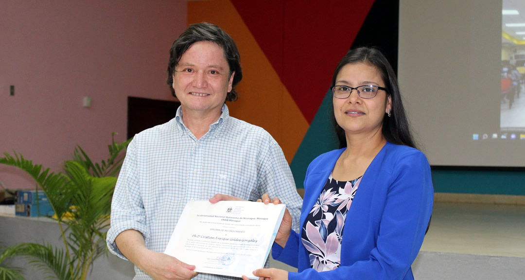 Máster Dayra Blandón entrega diploma de reconocimiento al doctor Geldes durante el encuentro