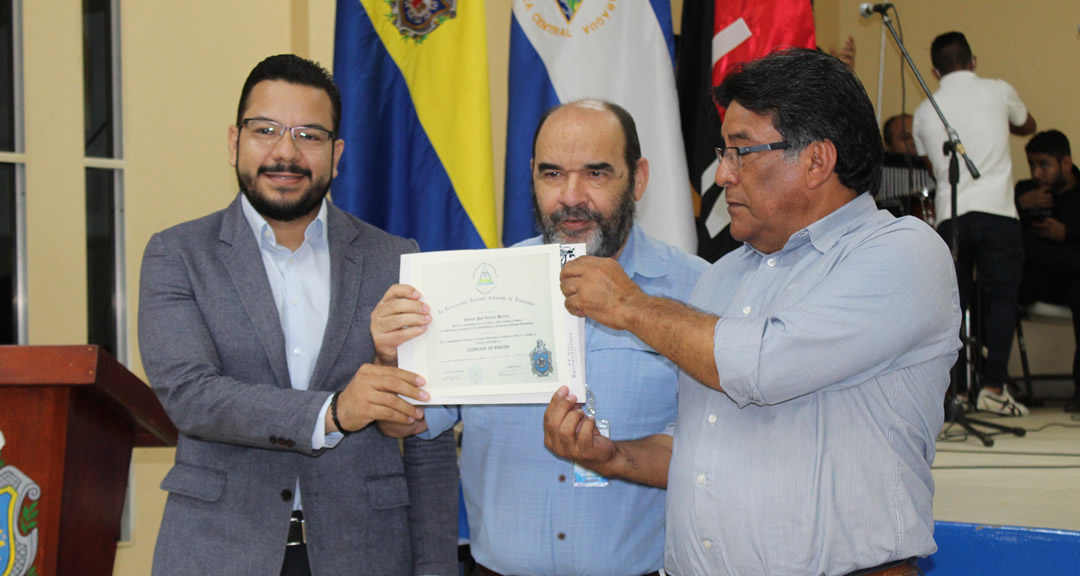 El Vicerrector General de la UNAN-Managua entrega a familiares de Roberto González una réplica de título emitido al joven universitario.