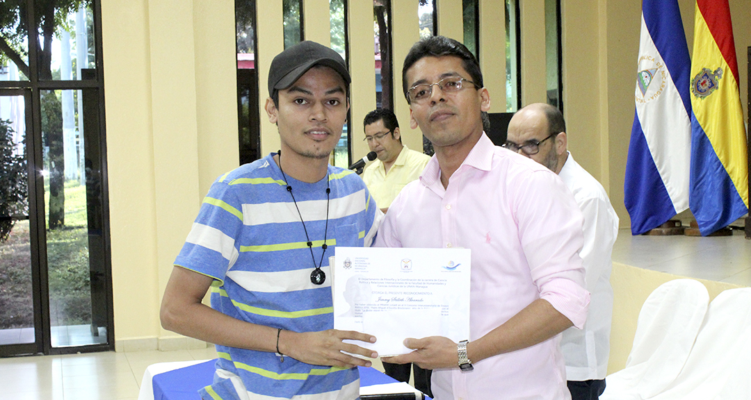 El Director del Departamento de Filosofía, entrega premio al estudiante  Jimmy Stilleth Alvarado, autor del ensayo ganador del primer lugar.