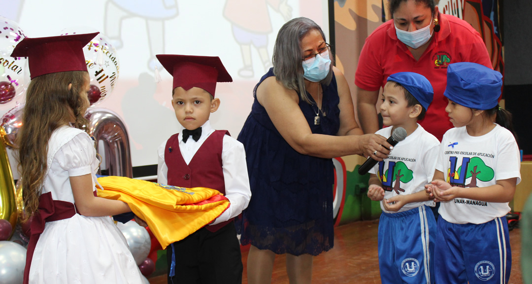 Estudiantes de tercer nivel hacen entrega de la bandera institucional a niños de segundo nivel