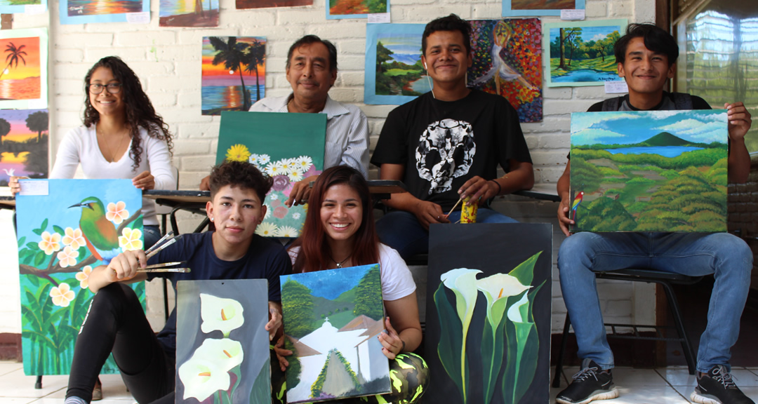 Universitarios junto a su maestro de dibujo y pintura durante la presentación de sus obras de fin de curso.