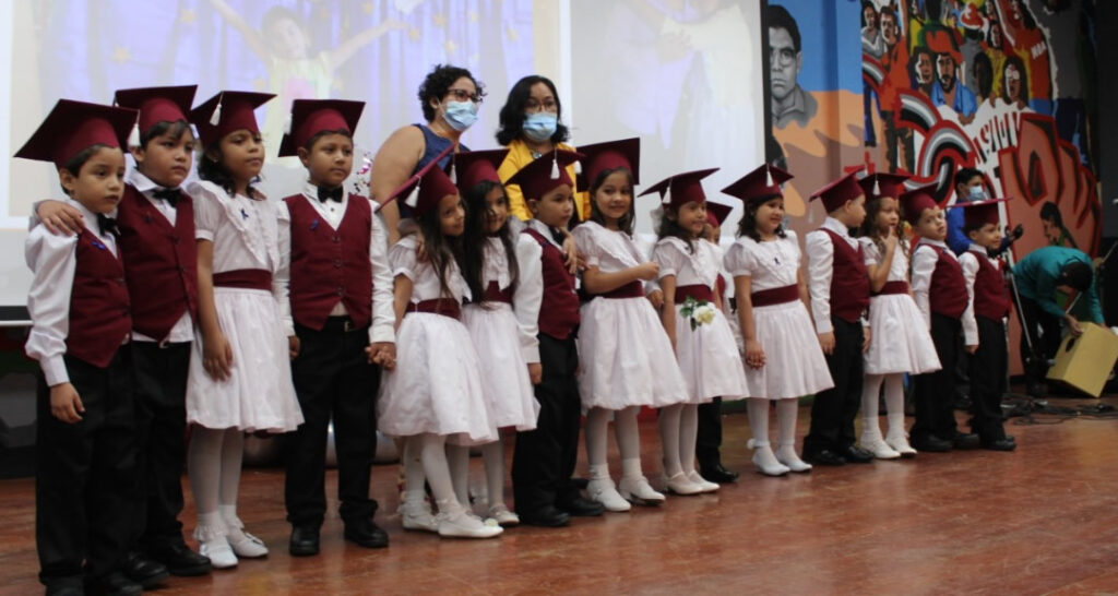 Niños y niñas del Centro de Aplicación Arlen Siu recibieron diplomas de culminación de tercer nivel preescolar. Autoridades universitarias celebraron junto a padres de familia este logro en el auditorio Fernando Gordillo Cervantes y se deleitaron con números culturales preparados por los pequeños. En su discurso de bienvenida, la Directora del Centro, maestra Inés Cano, sostuvo que esta trigésima promoción es gracias al aporte de las madres y padres de familia que han apoyado las iniciativas de desarrollo y seguridad a los niños con calidad y solidaridad. «Nos sentimos orgullosos de todos los estudiantes que egresan de nuestro Centro de Aplicación y les deseamos muchos éxitos en este nuevo camino que emprenderán», señaló. FOTO 2 Estudiantes de tercer nivel hacen entrega de la bandera institucional a niños de segundo nivel Por su parte, el MSc. Alejandro Genet, Decano de la Facultad de Educación e Idiomas, expresó que es muy importante brindarle seguimiento emocional y académico a los hijos para que desarrollen sus capacidades y aptitudes. «Nos da mucho orgullo ver niñas y niños que una vez que egresan y pasan los años regresan a su alma mater. Los procesos de formación e investigación que promovemos desde nuestras instancia nos hacen concretar nuestro compromiso con la educación inicial que brindamos a los escolares de nuestro Centro de Aplicación», puntualizó. Este evento culminó con la intervención del Vicerrector de Asuntos Estudiantiles, MSc. Bismark Santana, quien detalló con palabras emotivas el compromiso de educar con amor, principios y valores humanos. «Compartir con los niños y niñas esta faceta es muy satisfactoria. Mantenemos nuestra postura de apoyar este tipo de proyectos, los cuales, lamentablemente, se vieron afectados por la toma de la Universidad en el año 2018, pero gracias al apoyo de la familia universitaria, continuamos reconstruyendo lo que el golpismo quiso arrebatarnos», manifestó.