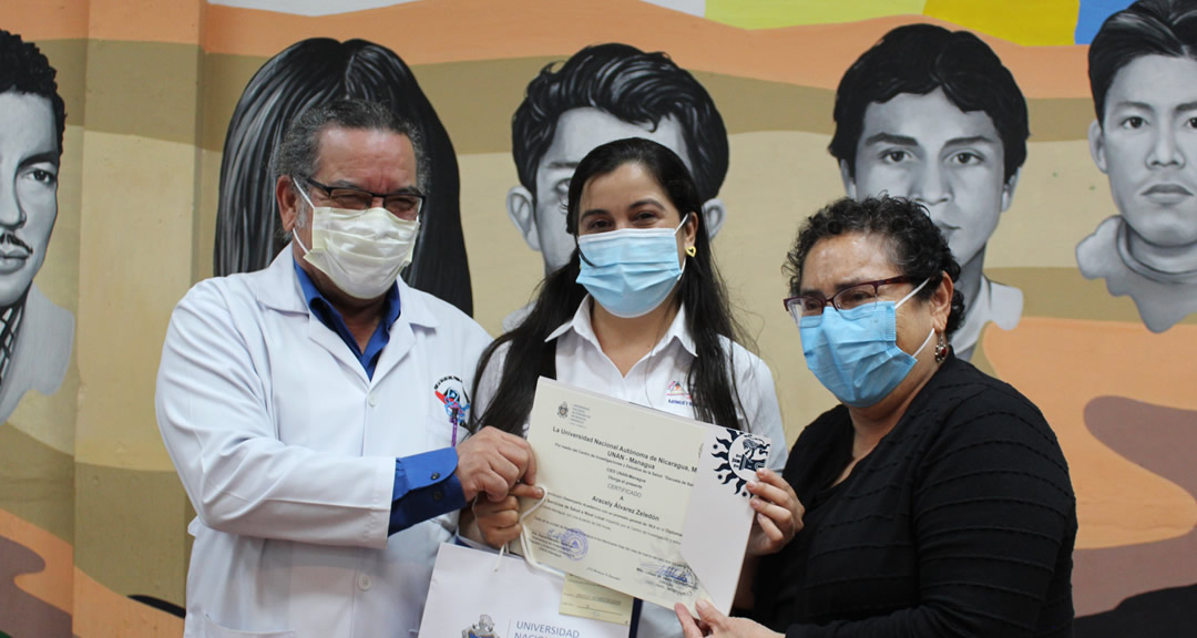 Representantes del MINSA y FETSALUD entregan reconocimiento a estudiante destacado.