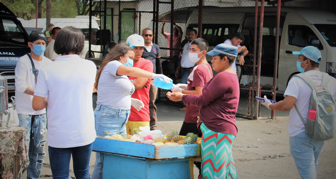 Estudiantes Universitarios aplicaron alcohol en gel a comerciantes de la UCA.